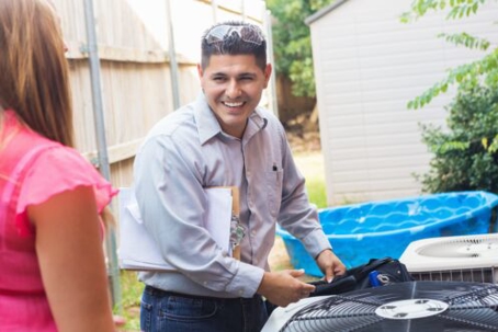 ac technician working on an outdoor ac unit